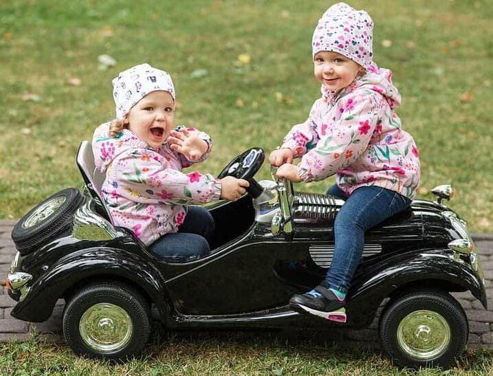 Two kids ride on the car